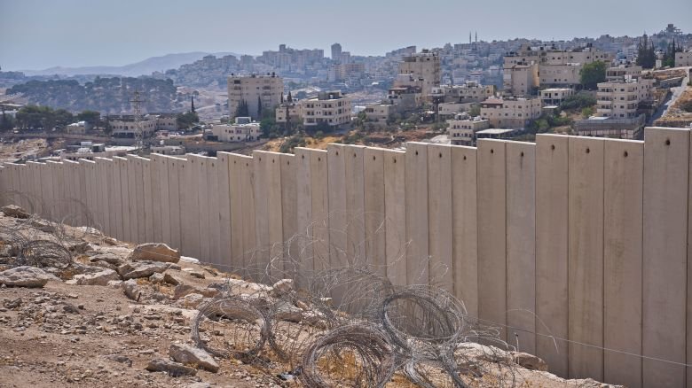 The separation wall next to the Arab neighborhood of Al-Eizariya, near where the Israeli government says housing units will be built as part of the E1 settlement development project, Thursday, Aug. 21, 2025. (AP Photo/Ohad Zwigenberg)