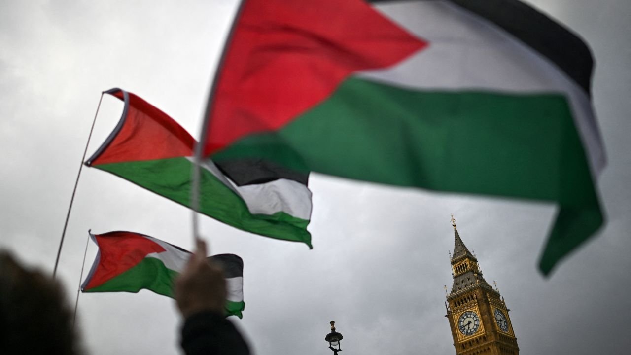 Pro-Palestinian activists and supporters hold placards and Palestinian flags as they gather in front of The Elizabeth Tower, commonly known by the name of the clock's bell "Big Ben", at the Palace of Westminster, home to the Houses of Parliament, in central London, on April 17, 2024 to protest against the export of arms from Britain to Israel.